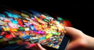 Una mano sostiene un teléfono móvil del que emergen numerosas imágenes que representan el crecimiento exponencial de la publicidad digital y la constante exposición de los usuarios a contenidos.