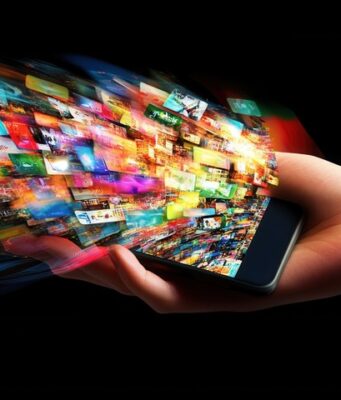 Una mano sostiene un teléfono móvil del que emergen numerosas imágenes que representan el crecimiento exponencial de la publicidad digital y la constante exposición de los usuarios a contenidos.
