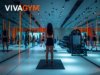 Sala de entrenamiento de un gimnasio VivaGym con una usuaria realizando ejercicio entre máquinas de fitness y zonas de entrenamiento funcional.