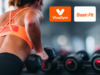 Mujer entrenando con pesas en un gimnasio junto a los logos de VivaGym y Basic-Fit, dos de las cadenas que protagonizan las fusiones en el sector de instalaciones deportivas y gimnasios en España.