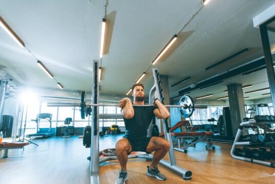Los beneficios de las cadenas de gimnasios crecen, pero no llegan a sus plantillas Hombre levantando una barra con pesas durante un entrenamiento en un establecimiento que pertenece a una cadena de gimnasios.