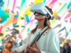 Mujer toca la guitarra con un visor de realidad virtual, una imagen que ilustra el avance de la inteligencia artificial en las industrias culturales.