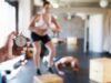 Entrenador cronometra el ejercicio de una mujer en un gimnasio, símbolo de unas plantillas que reclaman mejores condiciones laborales.