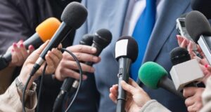 Varios periodistas acercan sus micrófonos a un portavoz, una imagen que ilustra la polémica por la clasificación ideológica de profesionales de la información elaborada por Interior.
