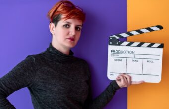 Mujer cineasta sostiene una claqueta, imagen sobre la desigualdad de presupuesto entre directoras y directores en el cine español.
