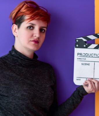 Mujer cineasta sostiene una claqueta, imagen sobre la desigualdad de presupuesto entre directoras y directores en el cine español.