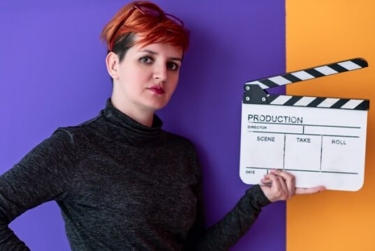 Las cineastas ganan presencia, pero dirigen con la mitad de presupuesto Mujer cineasta sostiene una claqueta, imagen sobre la desigualdad de presupuesto entre directoras y directores en el cine español.