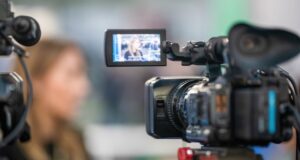 El sector audiovisual crece un 4,4 %, pero la transformación digital debe traducirse en empleo de calidad Cámara de televisión graba a una profesional en un sector audiovisual marcado por el auge del streaming.