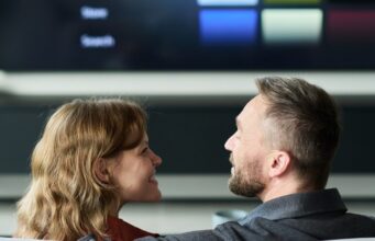 La prominencia, clave para el futuro del audiovisual público Pareja frente a un televisor inteligente con un menú de contenidos audiovisuales.