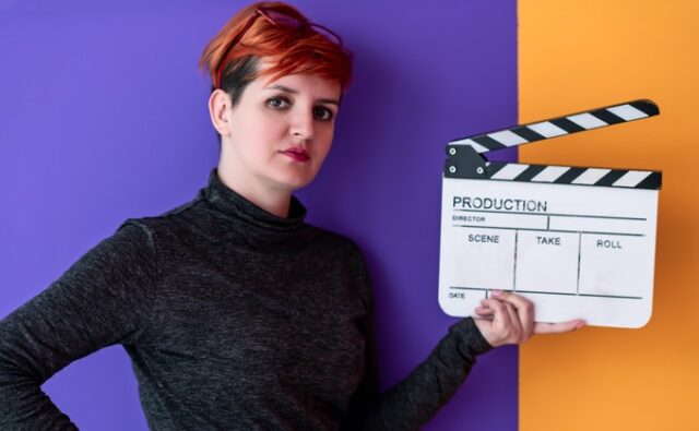 Mujer cineasta sostiene una claqueta, imagen sobre la desigualdad de presupuesto entre directoras y directores en el cine español.