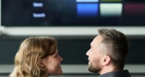 Pareja frente a un televisor inteligente con un menú de contenidos audiovisuales.