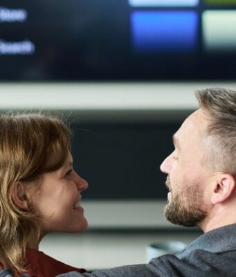 La prominencia, clave para el futuro del audiovisual público Pareja frente a un televisor inteligente con un menú de contenidos audiovisuales.