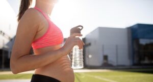El CSD refuerza las ayudas a la maternidad en el deporte Mujer embarazada con ropa deportiva y botella de agua durante un entrenamiento.