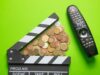 El sector audiovisual alerta del recorte del 30% en AgoraEU Claqueta de cine junto a monedas y un mando a distancia, en referencia a los recortes y la financiación del sector audiovisual.