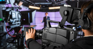 Operador de cámara graba un informativo en un estudio de televisión.
