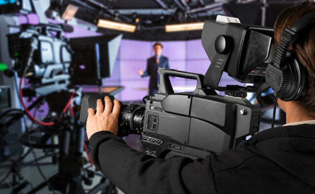 bbc-camera-680x420 Operador de cámara graba un informativo en un estudio de televisión.
