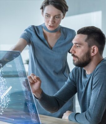 El uso desigual de la IA abre una nueva brecha laboral Una empleada le explica a un empleado cómo utilizar la inteligencia artificial en su trabajo.