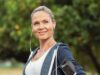 Mujer adulta con ropa deportiva y auriculares durante un entrenamiento al aire libre, en una noticia sobre la continuidad laboral en gimnasios después de los 45 años.