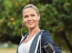 Trabajar en el deporte después de los 45: una carrera sin red Mujer adulta con ropa deportiva y auriculares durante un entrenamiento al aire libre, en una noticia sobre la continuidad laboral en gimnasios después de los 45 años.