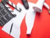 Netflix se suma a la oleada de recortes en el sector audiovisual Claqueta, mando de televisión y megáfono sobre documentos rotos, imagen de los recortes de empleo y la reestructuración en el sector audiovisual.