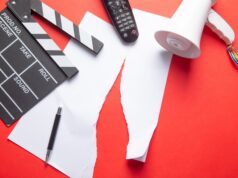 Claqueta, mando de televisión y megáfono sobre documentos rotos, imagen de los recortes de empleo y la reestructuración en el sector audiovisual.