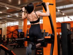 Una mujer hace dominadas en un gimnasio VivaGym, cadena de gimnasios que va a adquirir Synergym.
