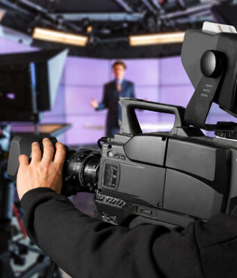 Operador de cámara graba un informativo en un estudio de televisión.