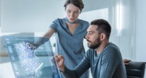 Una empleada le explica a un empleado cómo utilizar la inteligencia artificial en su trabajo.