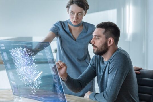 El uso desigual de la IA abre una nueva brecha laboral Una empleada le explica a un empleado cómo utilizar la inteligencia artificial en su trabajo.